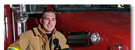 Fireman leaning against fire truck.