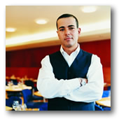 New England Culinary Institute student standing with a restaurant in the background