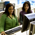 Two students at a desktop computer.