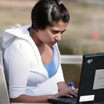 St. John's online student at her IBM laptop